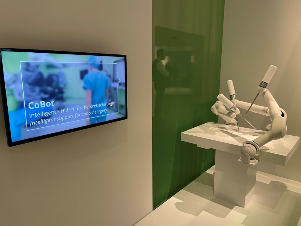 Ausstellungsfläche im Hygiene-Museum zeigt Monitor mit Video und Operationsroboter