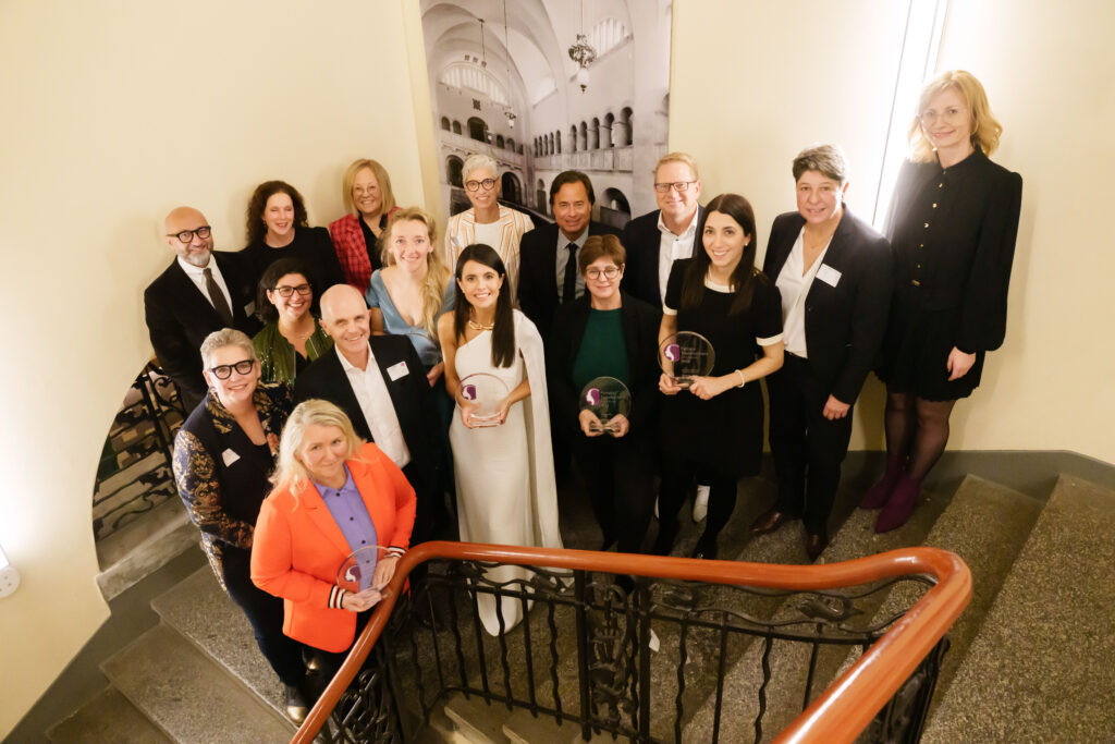 Group of award winners and event team standing on the stairs and the photo was taken from a higher level.