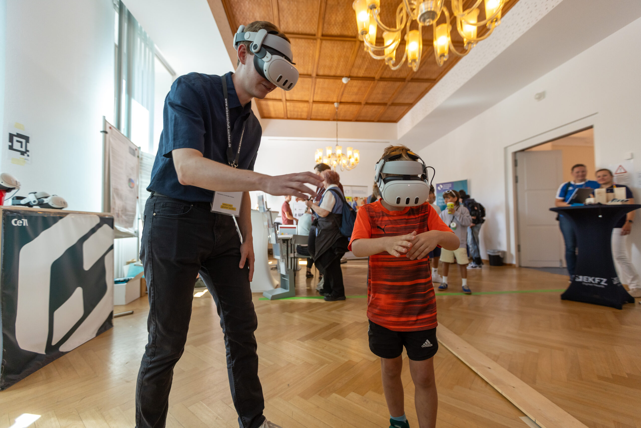 Young man and child wearing VR-glasses touching virtual spiders