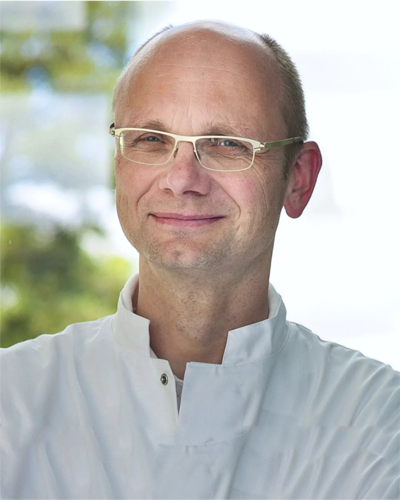 man with glasses wearing a doctors goan