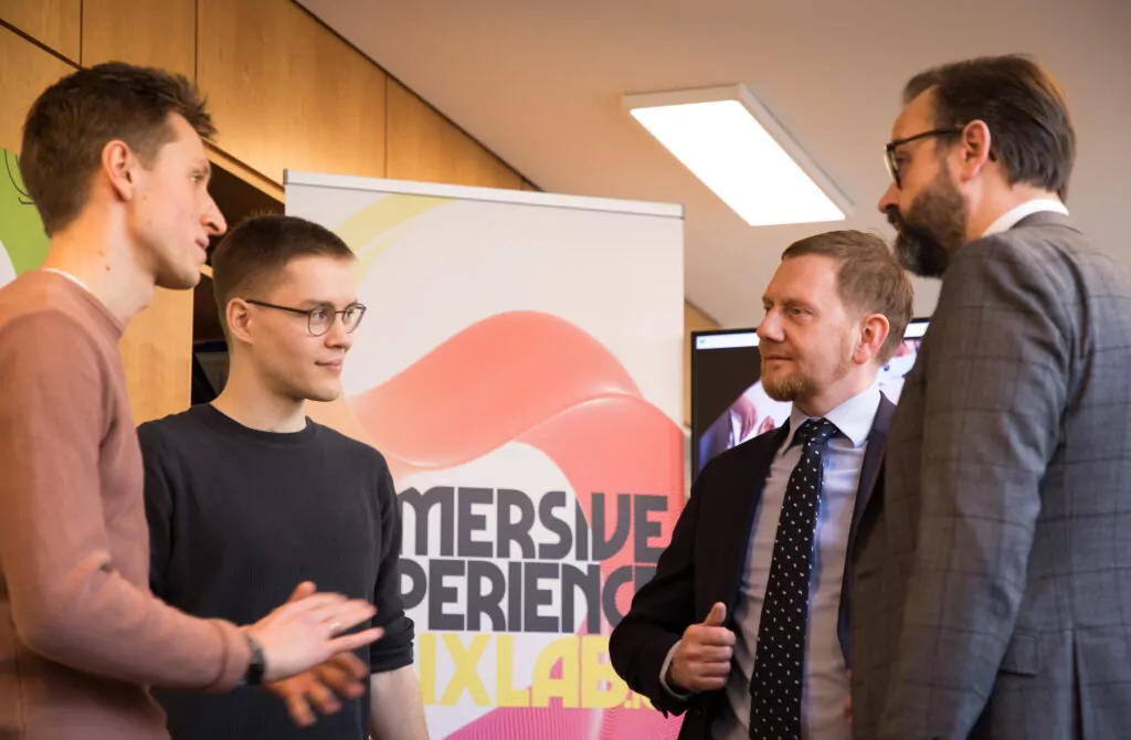 4 men standing together talking