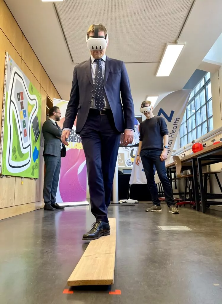 Prime Minister Michael Kretschmer walking the plank wearing VR glasses