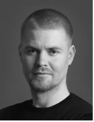 black and white portrait of a man with short hair and beard wearing a black shirt