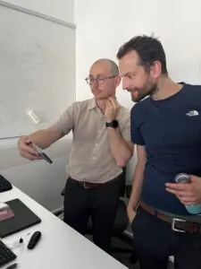 Zwei männliche Personen schauen fasziniert auf ein Bild am Handy