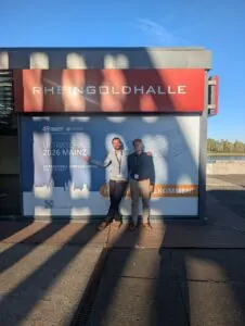 Zwei Männer stehen vor der Rheingoldhalle in Mainz